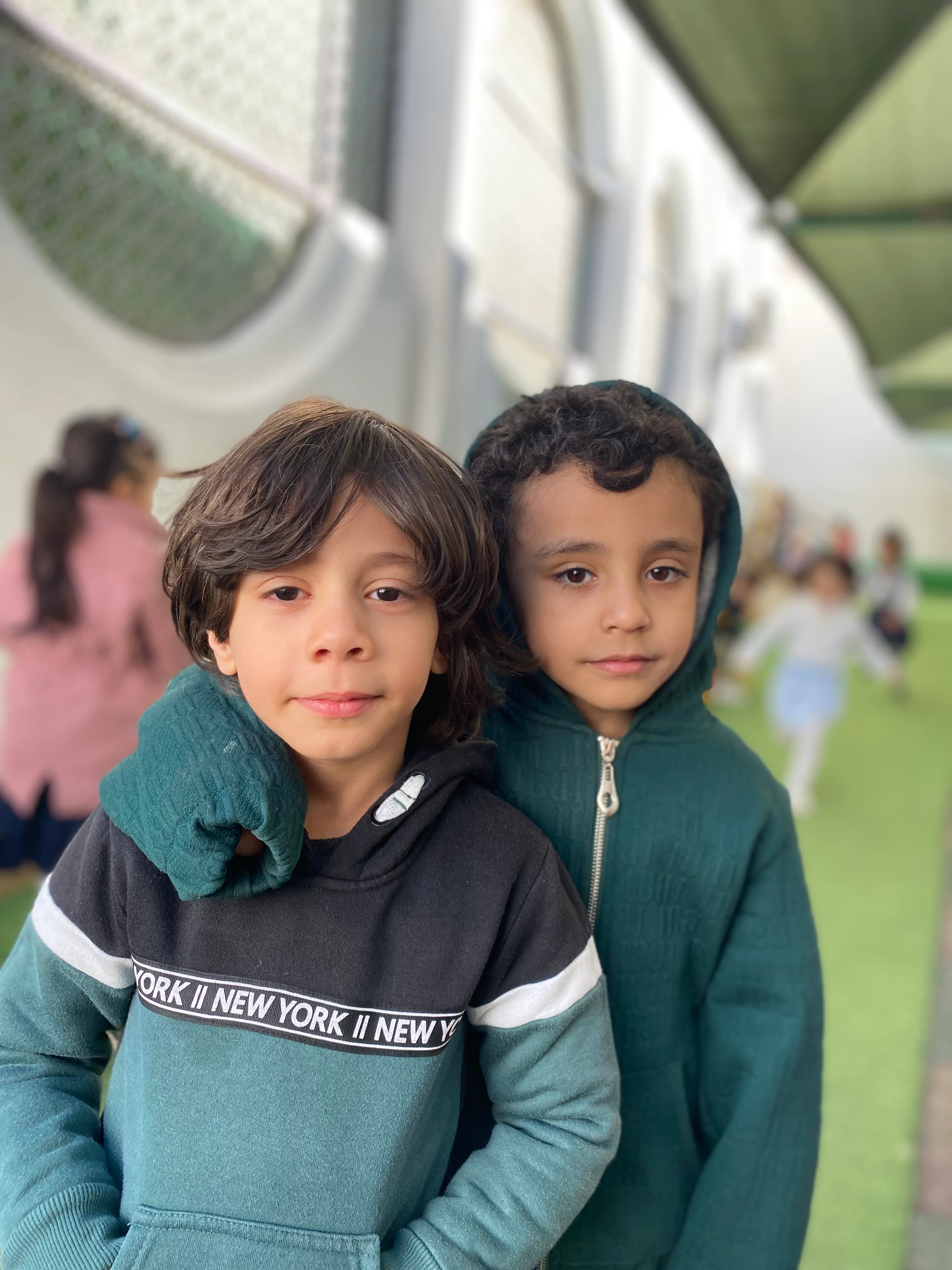 Two young pupils together on the school grounds